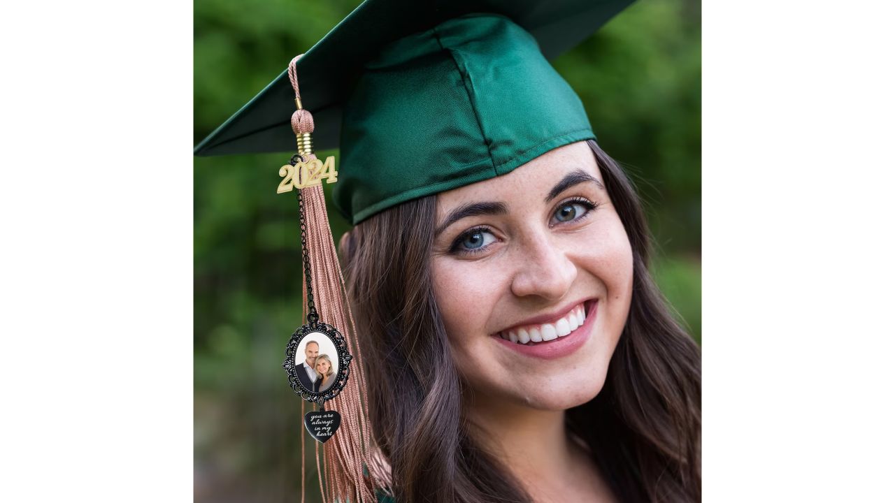 Woman in a green graduation cap with a photo charm