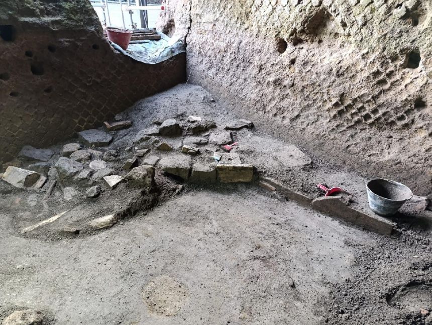 The probable remains of a staircase made with reused tiles and marble fragments are seen on top of volcanic ash.