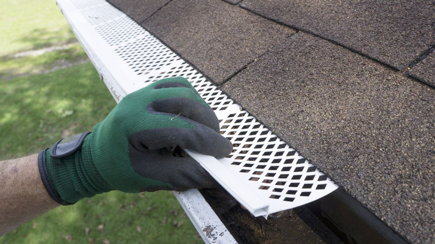 A professional installer is putting in a plastic gutter guard.