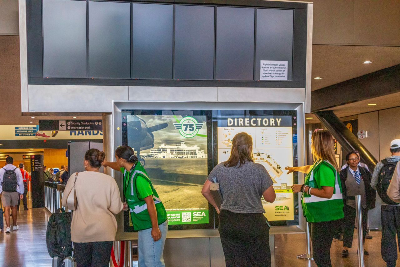 In a file photo from August, Seattle-Tacoma International Airport employees assist travelers during a system outage.