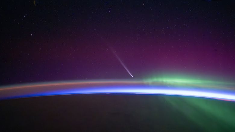 Comet rises up over the horizon just before orbital sunrise with aurora streaking by.