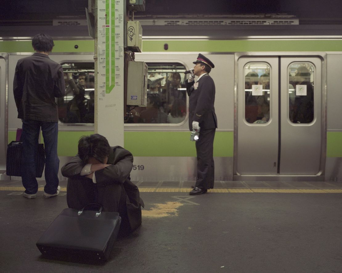 A drunk man sits on a platform of the Yamanote Line in Tokyo, Japan on March, 14, 2004.