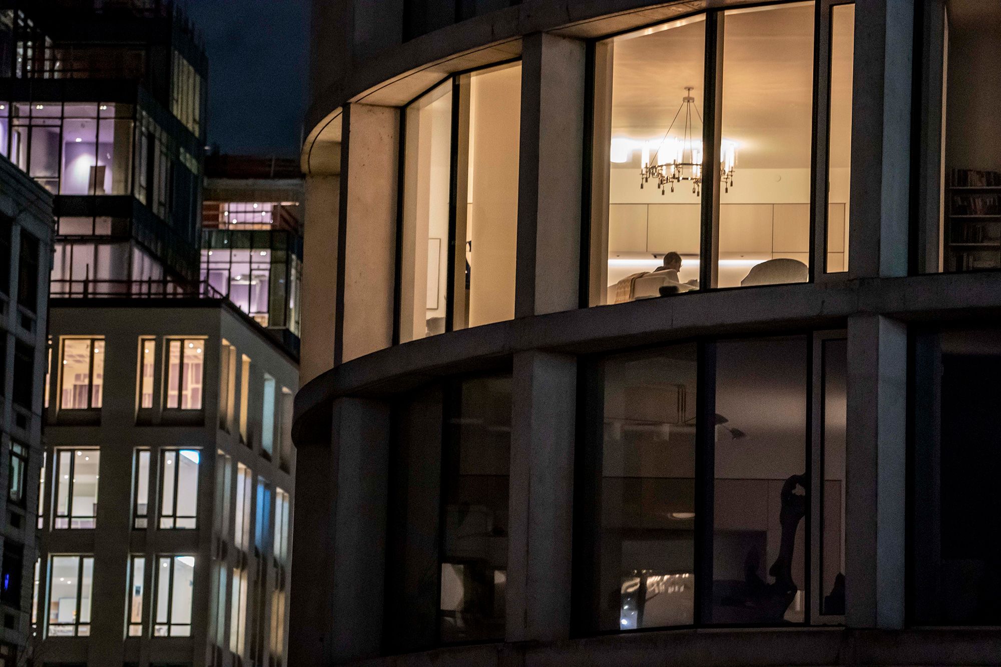 A night-time view of apartment buildings — and a look into apartments-turned-worlds amid Covid-19 lockdowns — in downtown New York City on April 4, 2020.