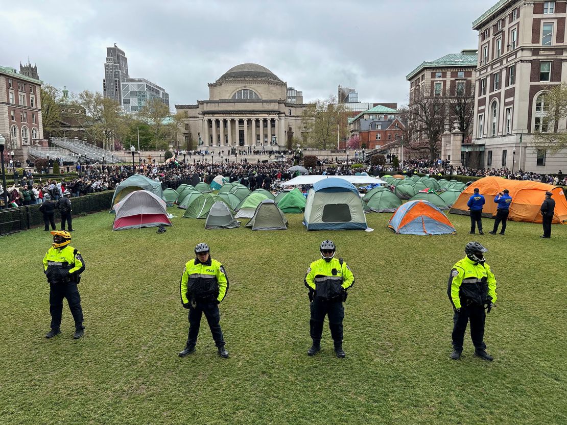 Police officers stand near tents erected by pro-Palestinian protesters on the South Lawn at Columbia University in New York, on Thursday.