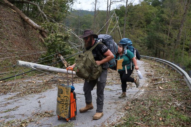 People evacuate by foot on Highway 64 near the Bat Cave community of North Carolina, on Monday, September 30.