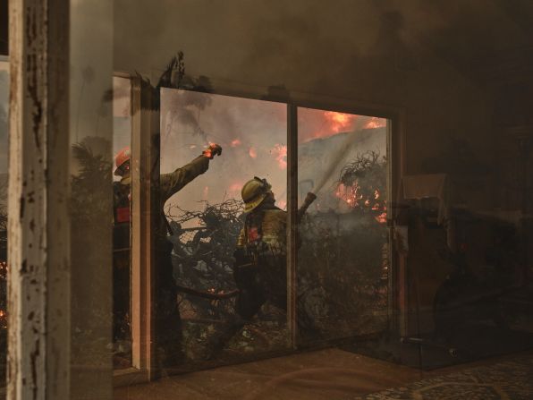 Firefighters work to put out the wildfire in Pacific Palisades.