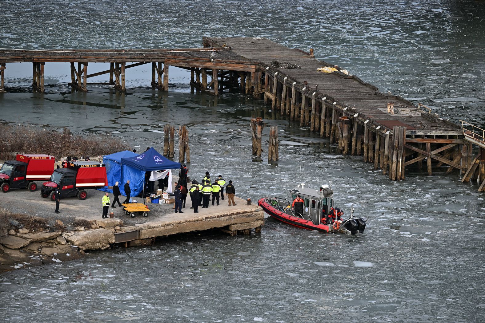 Multiple agencies work on a dock near the wreckage site on Thursday.