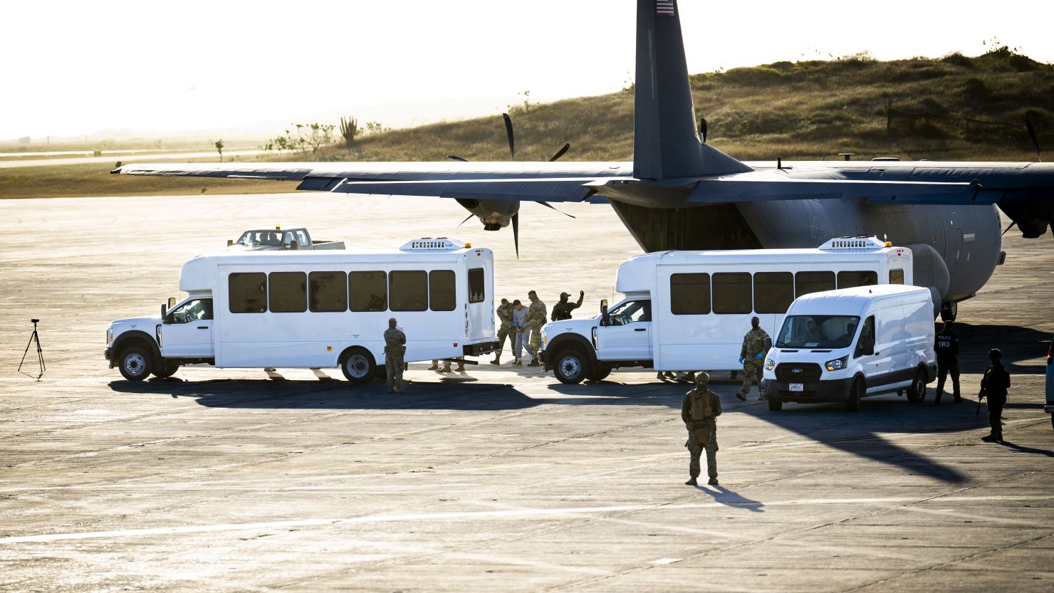 In this photo reviewed by the US military, security forces lead a man in gray sweatsuit away from a a military cargo plane that transported deportees from El Paso, Texas, to Guantánamo Bay, Cuba, on February 7.