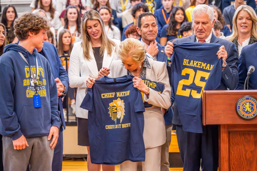 Education Secretary Linda McMahon holds a jersey during a news conference at Massapequa High School on May 30.
