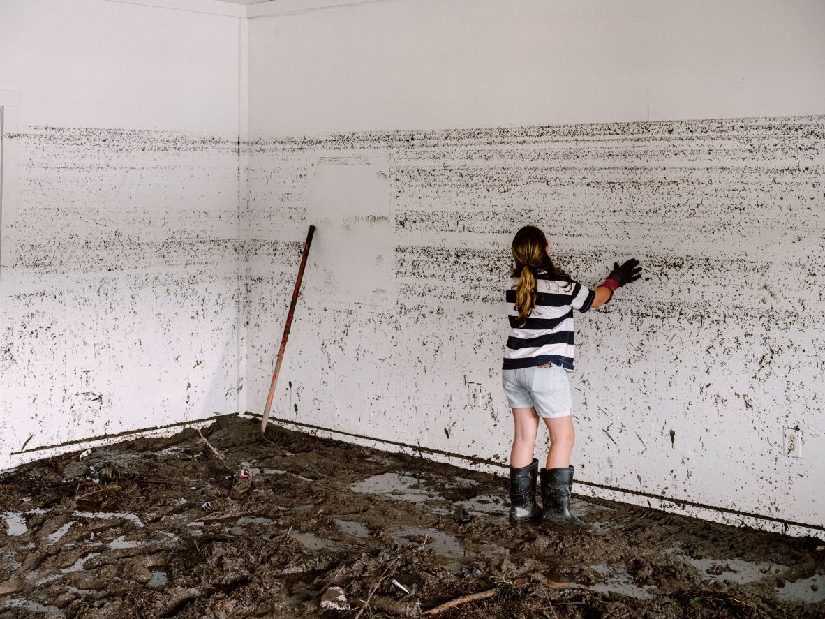 The daughter of the owner of Vintage Hair Co. looks at water lines on the wall of the destroyed salon in Ingram on Saturday, July 5.
