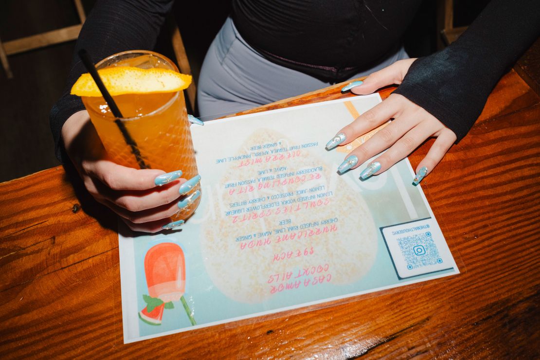 A watch party attendee holds a "Love Island USA"-themed cocktail called the "Cierra Mist" during a watch party at the Malt House in New York on July 1.