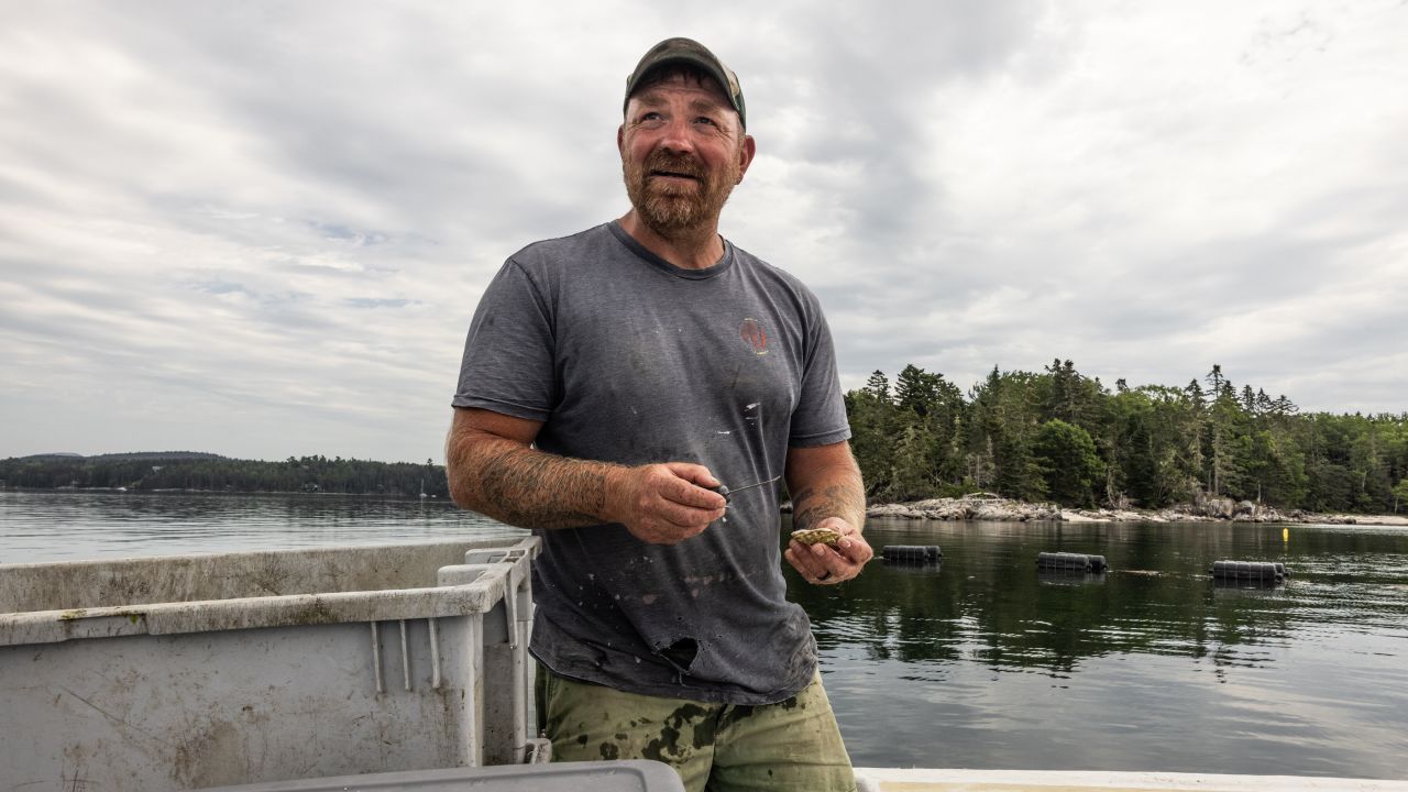 FILE -- Graham Platner shucks oysters on site of the farm he co-runs in Waukeag Neck Oyster Co. in the Frenchman Bay in Sullivan, Maine, June 25, 2025. A new crop of candidates has turned away from the aspirational "American dream" message of campaigns past and is leaning into how difficult life can be for working people -- including them. (Greta Rybus/The New York Times)