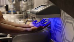 An employee at Just Salad scans their hands for contamination using PathSpot's scanner.