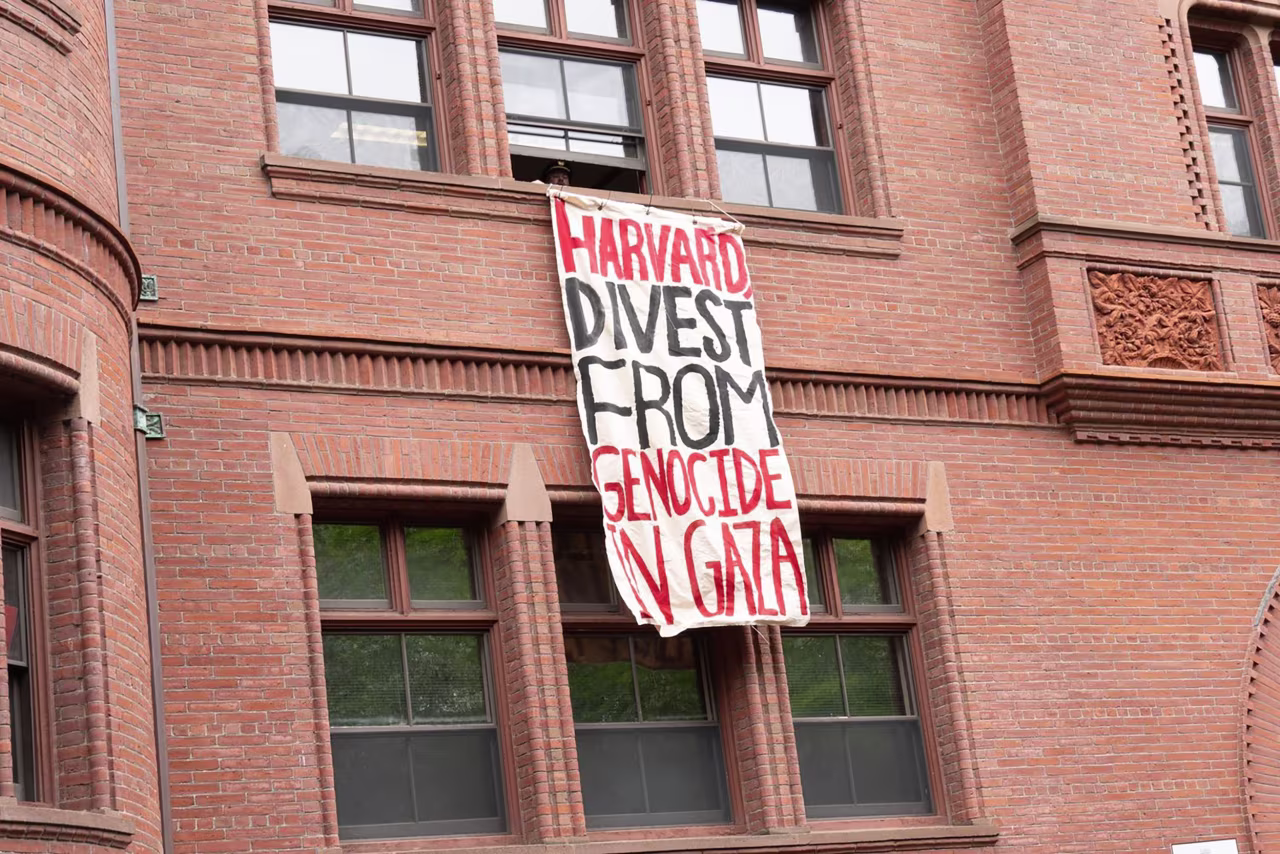 A protest banner is seen unfurled at Sever Hall during Thursday's commencement.