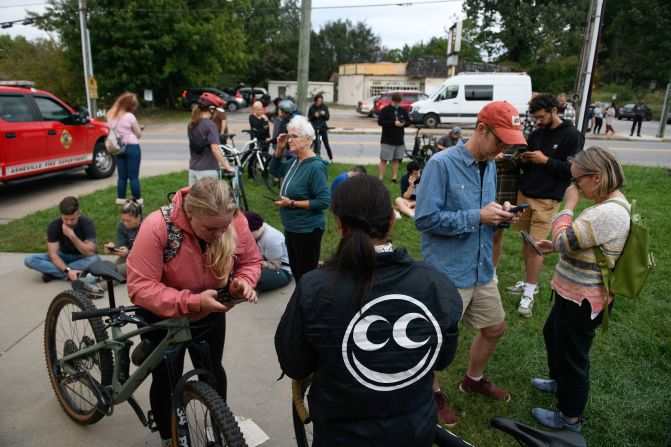 People gather at a fire station to access WiFi on Saturday after Hurricane Helene moved through Asheville, North Carolina.