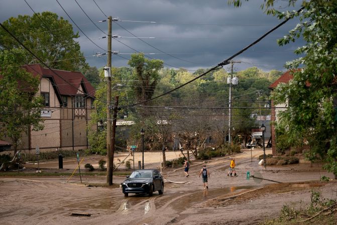 People inspect flood damage in Asheville, North Carolina, on Saturday.