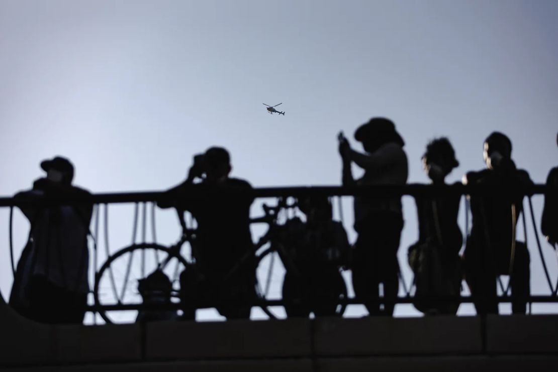 Un helicóptero policial sobrevuela a los manifestantes frente al edificio federal Robert Young el 9 de junio en el centro de Los Ángeles.