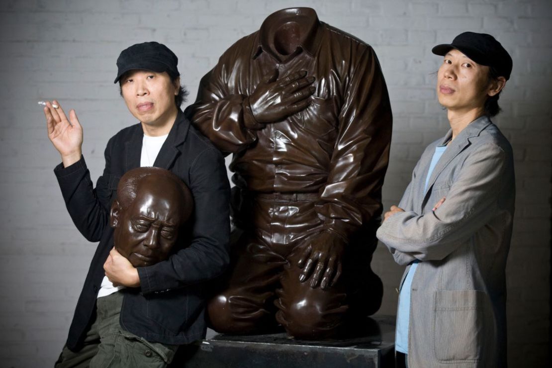 Los hermanos artistas Gao Zhen (izquierda) y Gao Qiang (derecha) fotografiados con su escultura "La culpa de Mao" en Beijing, China, en 2009.