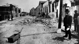 Charleston County, Charleston, South Carolina.   Charleston Earthquake of August 31, 1886.Wrecked brick house on Tradd Street. 

William John McGee of the U.S.Geological Survey inspecting a fissure near a wrecked brick house on Tradd Street.  A cardboard focimeter is propped against the telephone pole, with a map of Charleston nearby" from Susan Millar Williams. 