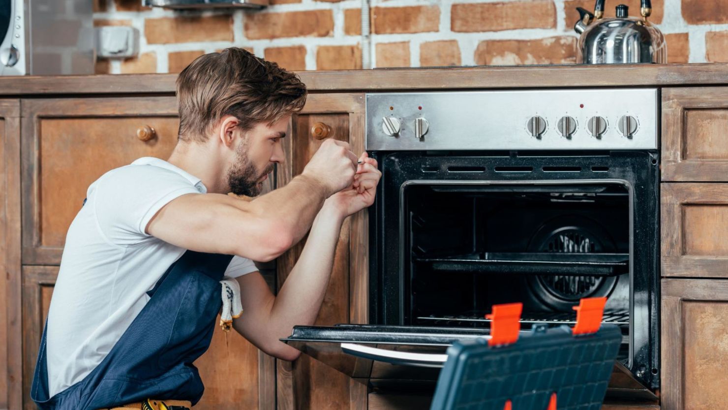 Service technician fixing a homeowner’s oven.