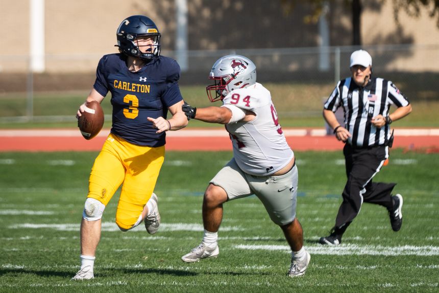 Jack Curtis looks downfield as he evades a tackler during Carleton College's homecoming game this year.