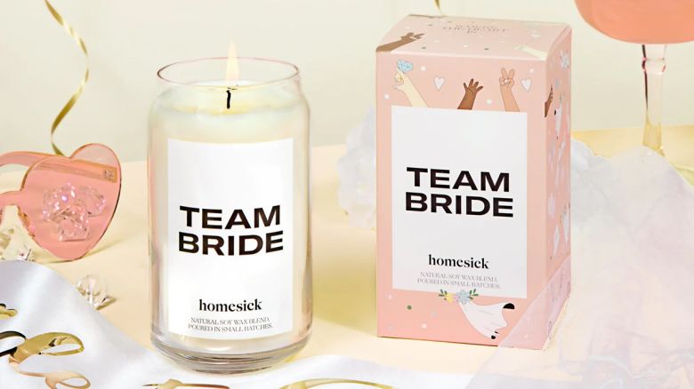 A Homesick Team Bride Candle and its box on a table outfitted with party decor.