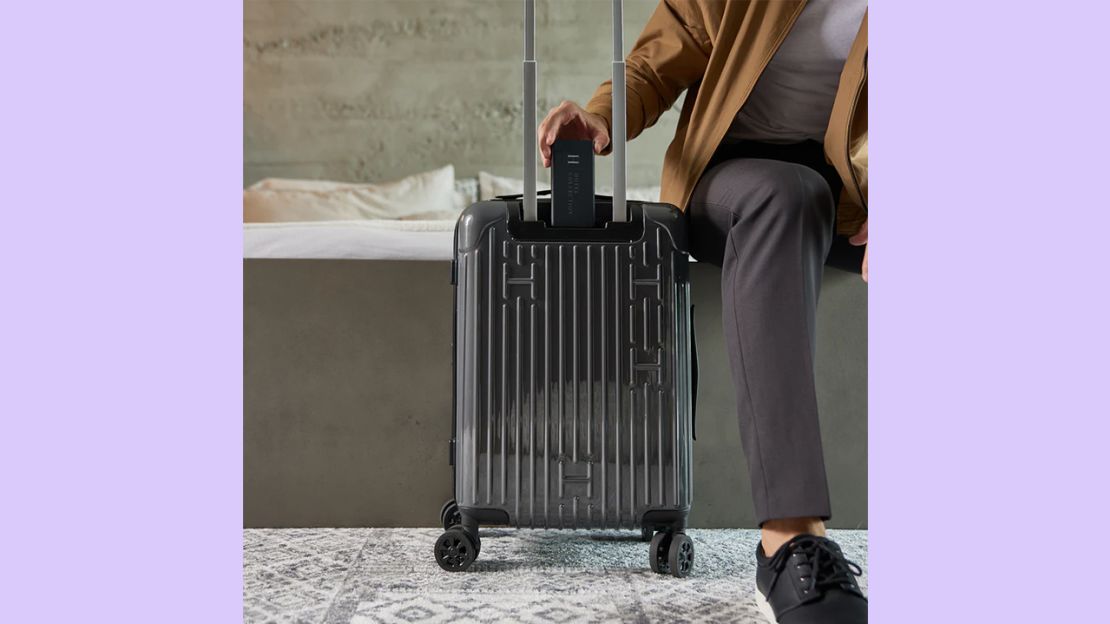 A photo of a person taking the removable battery out of a Hotel Collection Carry-On bag