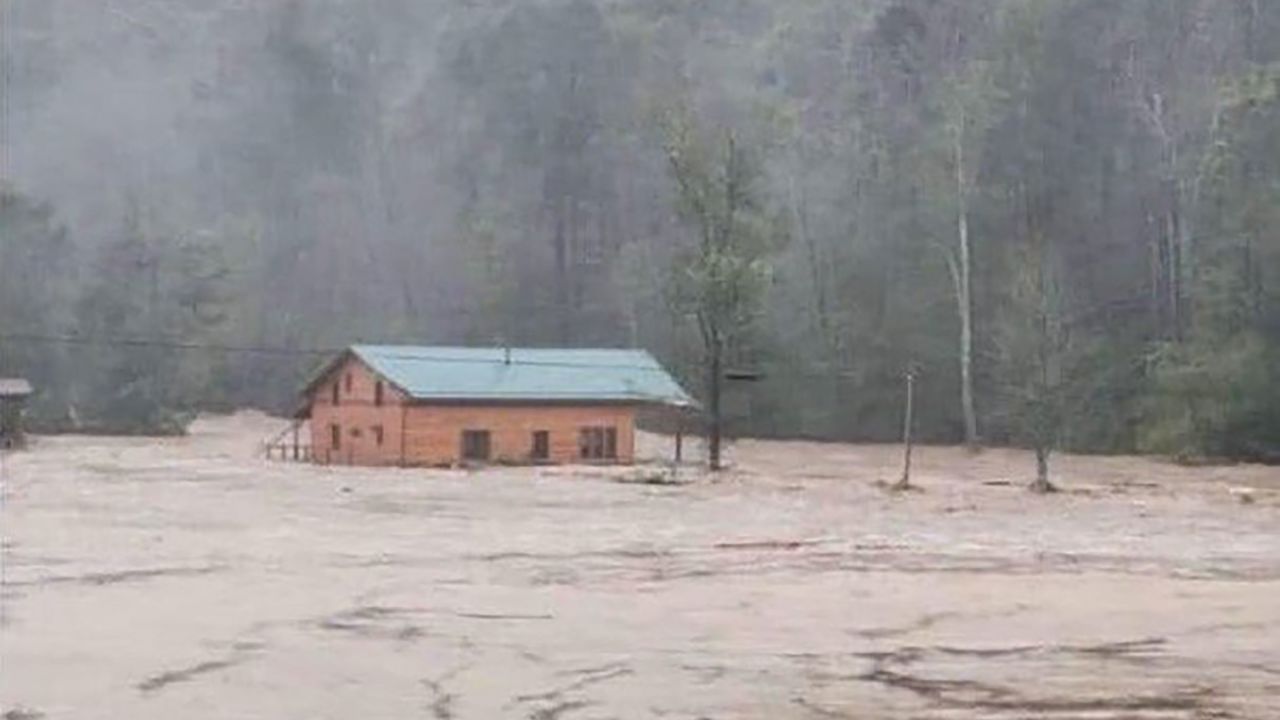 Kim Ashby and her husband, Rod, were at their home in Elk Park, North Carolina, on Friday when it was swept away by floodwaters. Kim Ashby is still missing. A neighbor captured a photo of the home as it floated down the river.