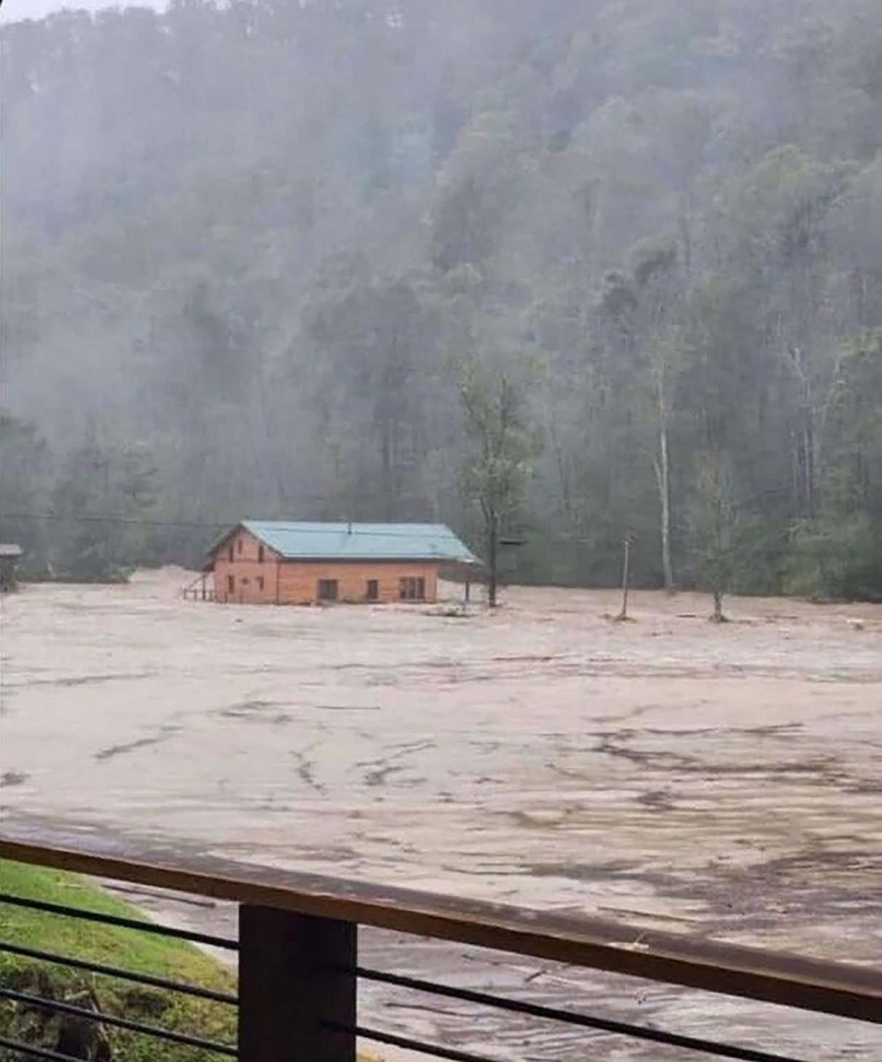 Kim Ashby and her husband, Rod, were at their home in Elk Park, North Carolina, on Friday when it was swept away by floodwaters. Kim Ashby is still missing. A neighbor captured a photo of the home as it floated down the river.