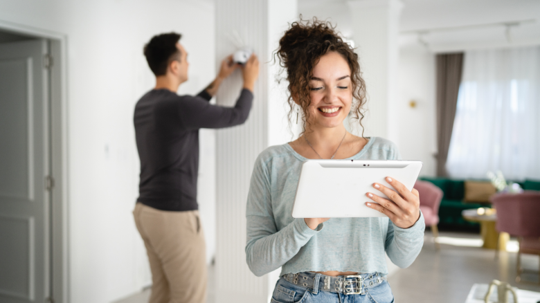 Young couple setting up a home surveillance security camera.