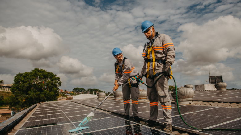 Two workers cleaning solar panels