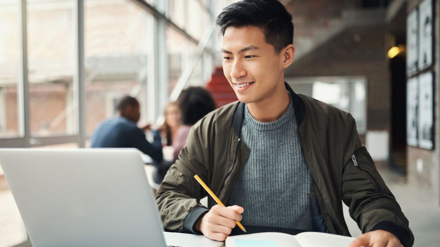 Man studying with laptop and notebook