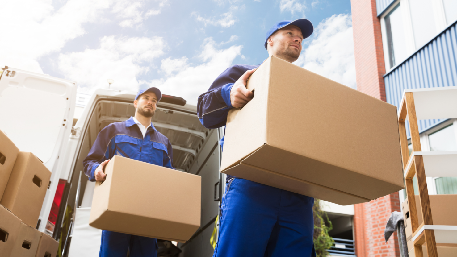 A pair of movers unloading cardboard boxes