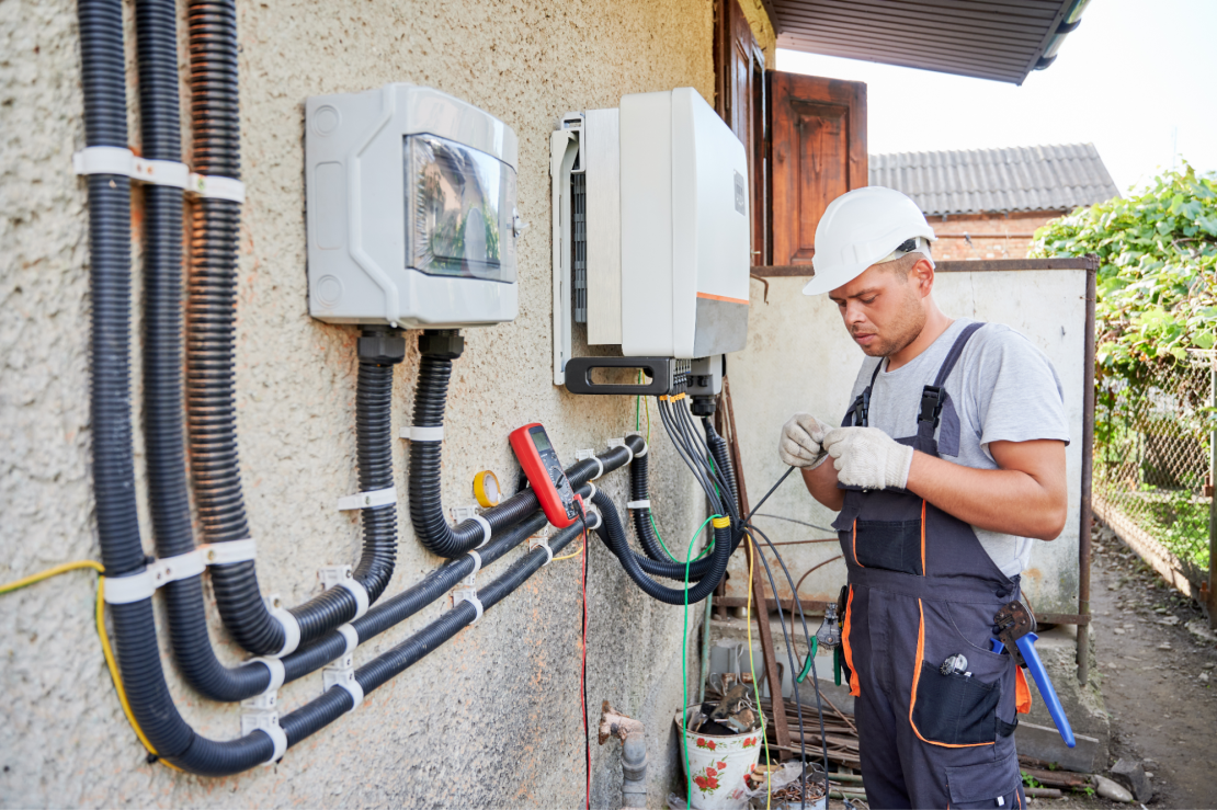 Worker connects solar to home electrical box.