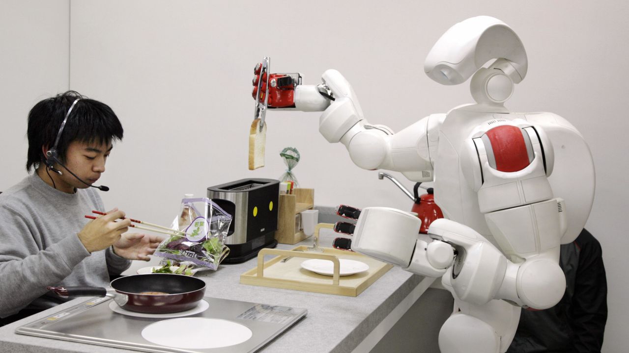 The new humanoid robot "Twendy-one", developed by Japan's Waseda University, picks up a piece of bread from a toaster during a demonstration at Waseda's laboratory in Tokyo, 27 November 2007. The Twendy-one, equipped with 47 actuators and two CCD on its 111kg body, has been developed for nursery and household assistance work.  AFP PHOTO / Yoshikazu TSUNO (Photo credit should read YOSHIKAZU TSUNO/AFP via Getty Images)