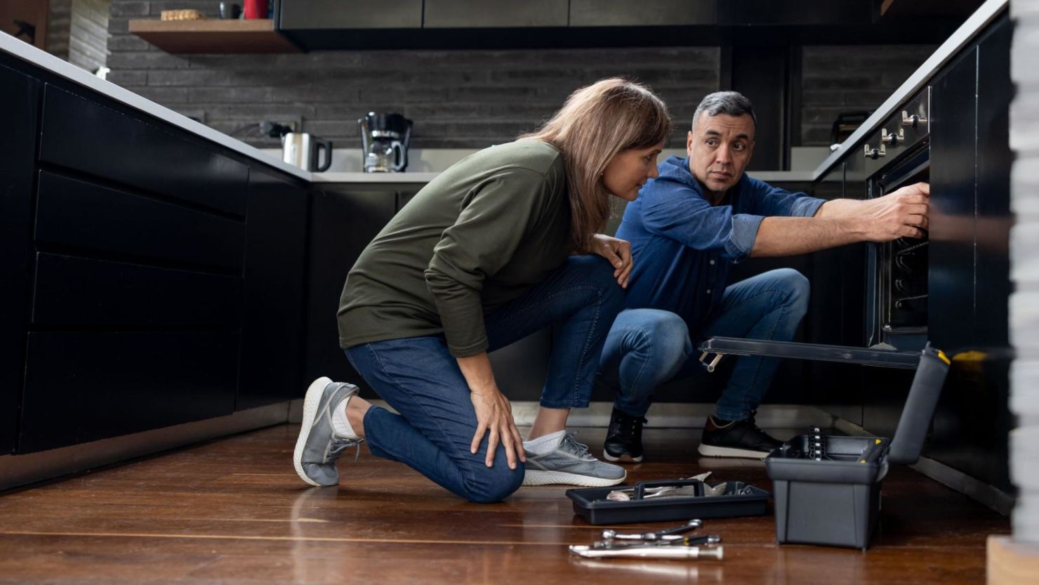 The service technician shows a homeowner what’s wrong with their oven.