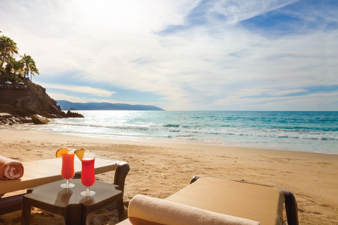 A photo of the beach at the Hyatt Ziva Puerto Vallarta with two beach chairs in the foreground