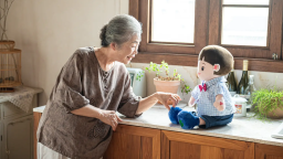 An elderly woman interacts with an AI-powered Hyodol plushie robot companion.