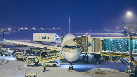 A photo of a Qatar Airways Airbus A320 covered in snow at Prague Airport