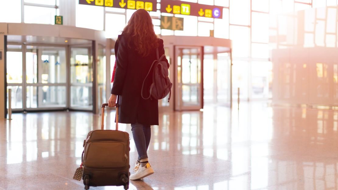 underscored woman walking into airport