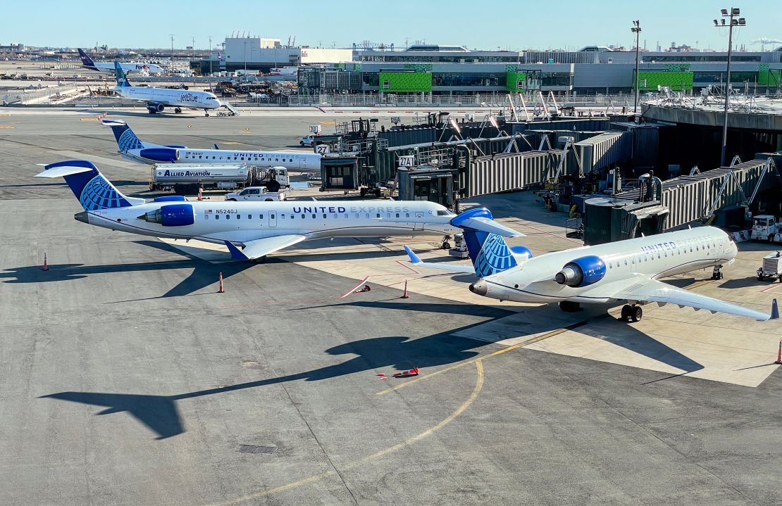 A photo of three United Express jets parked at the gate in Newark Liberty International Airport (EWR)