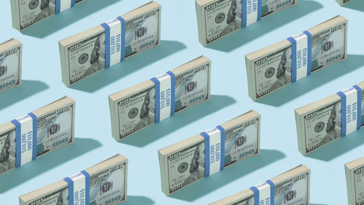 A pattern of American one hundred dollar bills on a blue background.