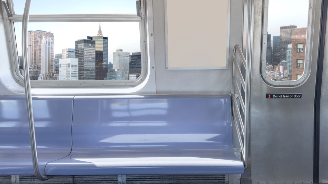 View from the inside of a New York City Subway car passing by the Manhattan skyline.