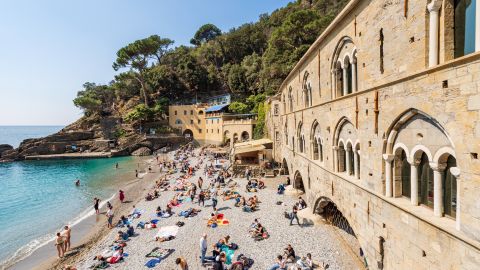 A photo of tourists on a beach in San Fruttuoso, Italy