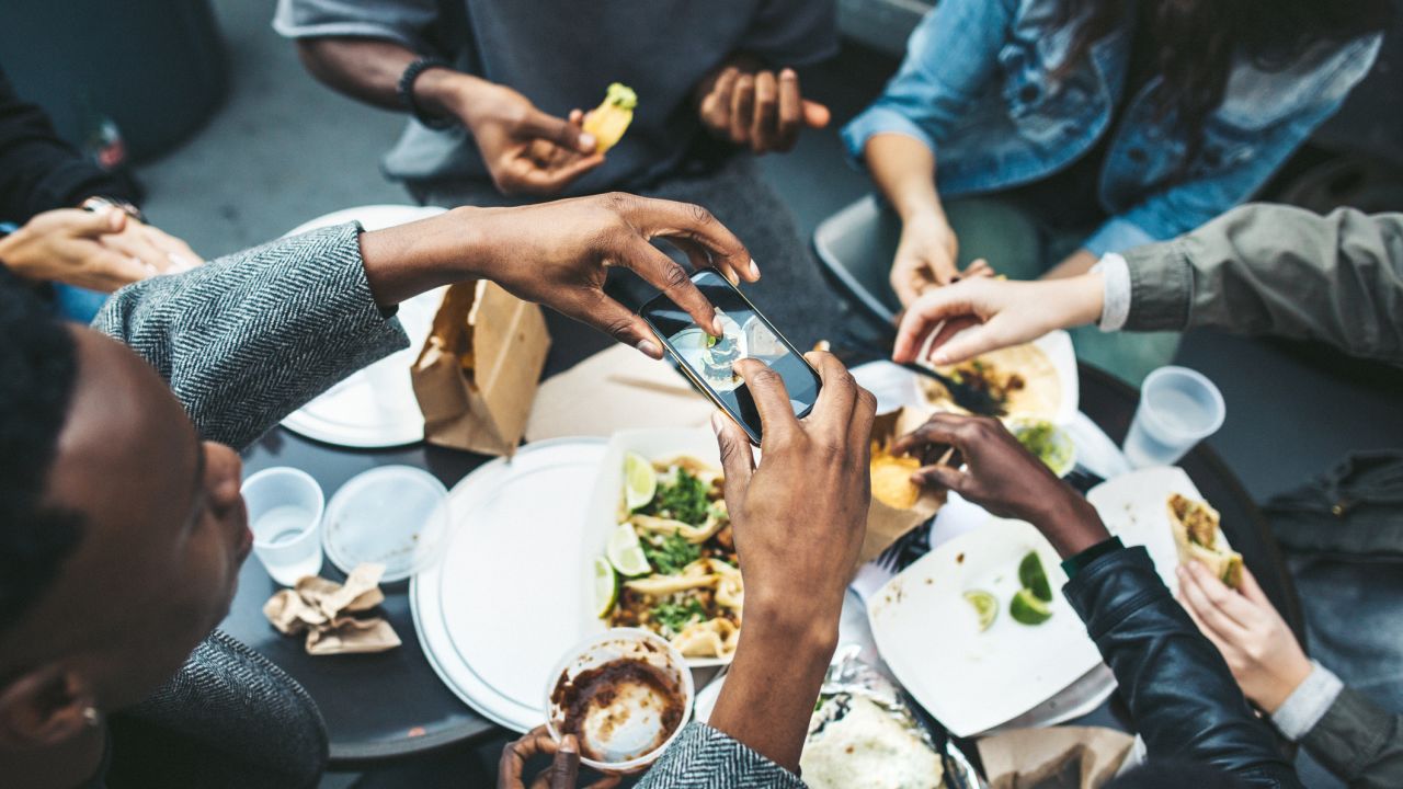 A group of people eating tacos outdoors