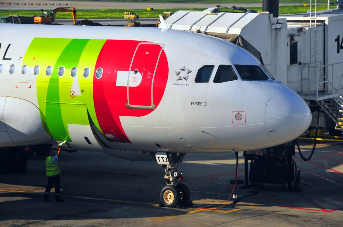 A photo of a TAP Air Portugal plane at the gate in Lisbon International Airport