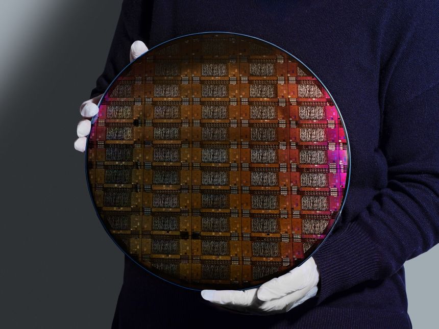 An IBM researcher holds the wafer, or the slice of silicon used to create processors and chips, for the companyâ€™s Loon experimental quantum processor.