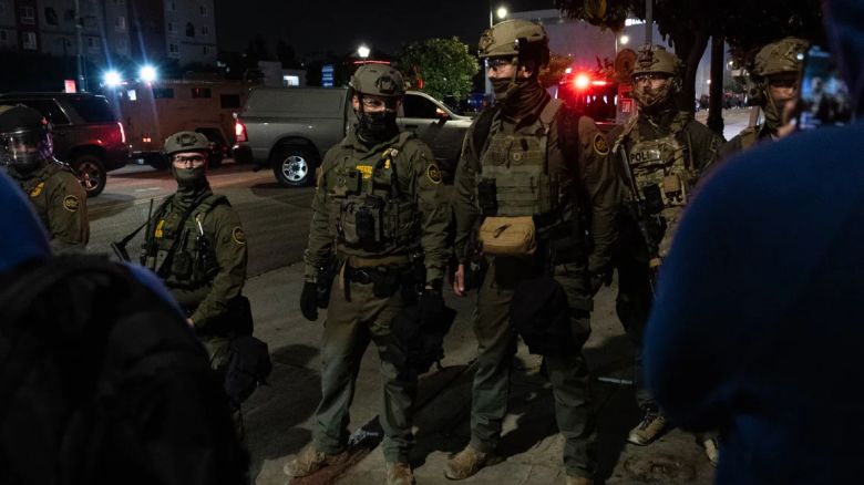 Los oficiales de ICE forman una barrera para bloquear a los manifestantes después de realizar una redada en Chinatown el 6 de junio en Los Ángeles, California