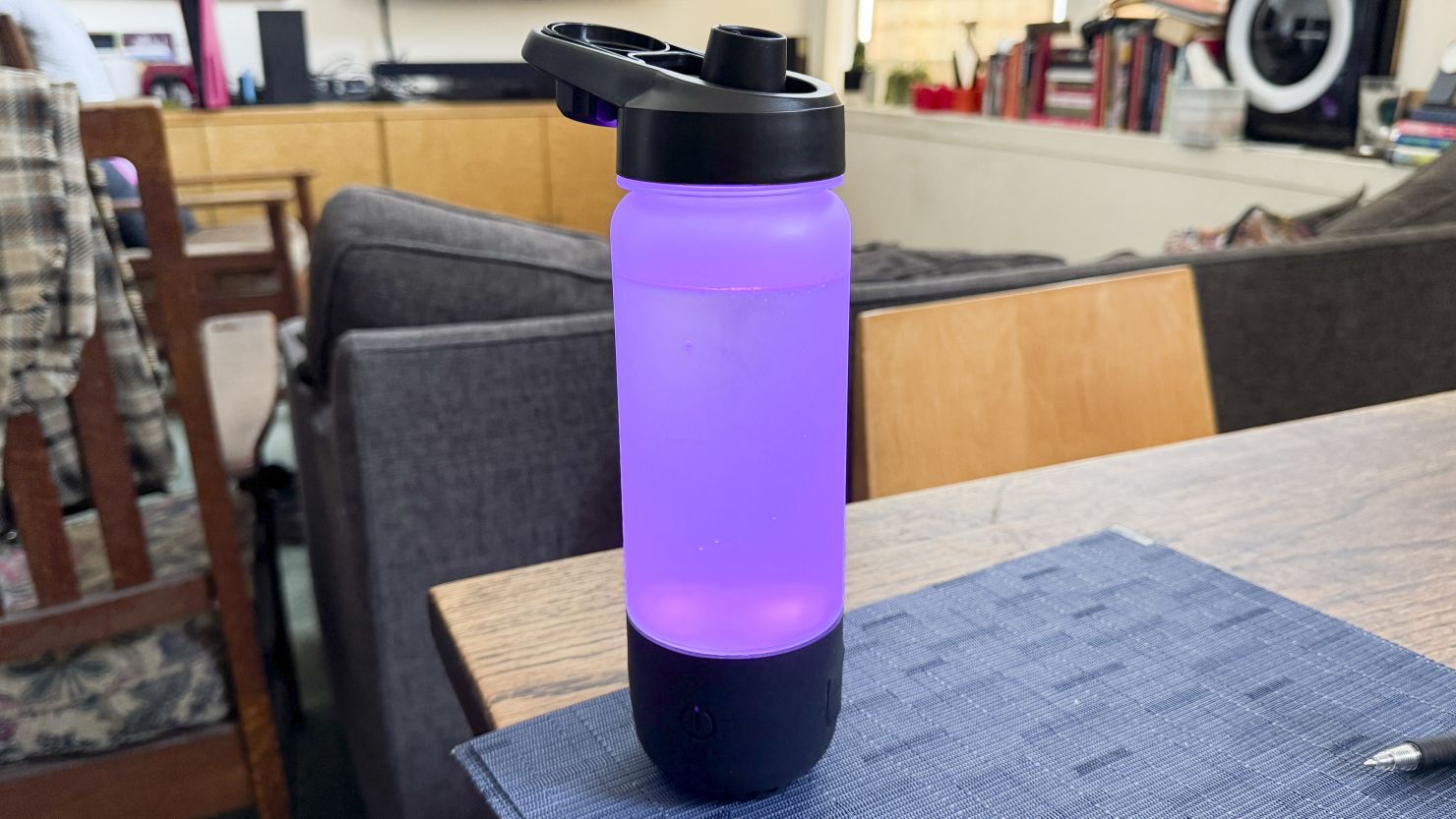 The Icewater 3 in 1 smart water bottle glows purple on a table.