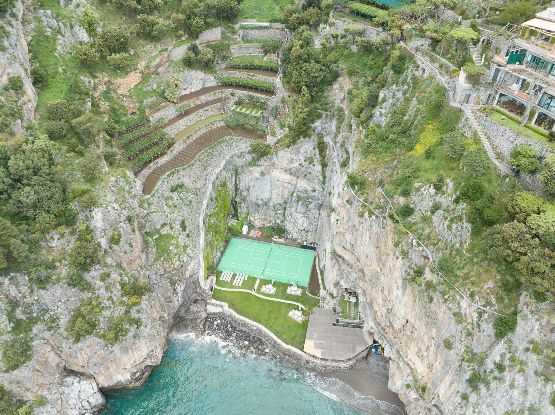 Reached by a few hundred steps, the tennis court at Hotel Il San Pietro Di Positano in Italy is between the cliff face and the pebble beach.